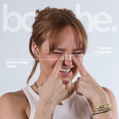 Women applying nasal strip on the bridge of her nose.