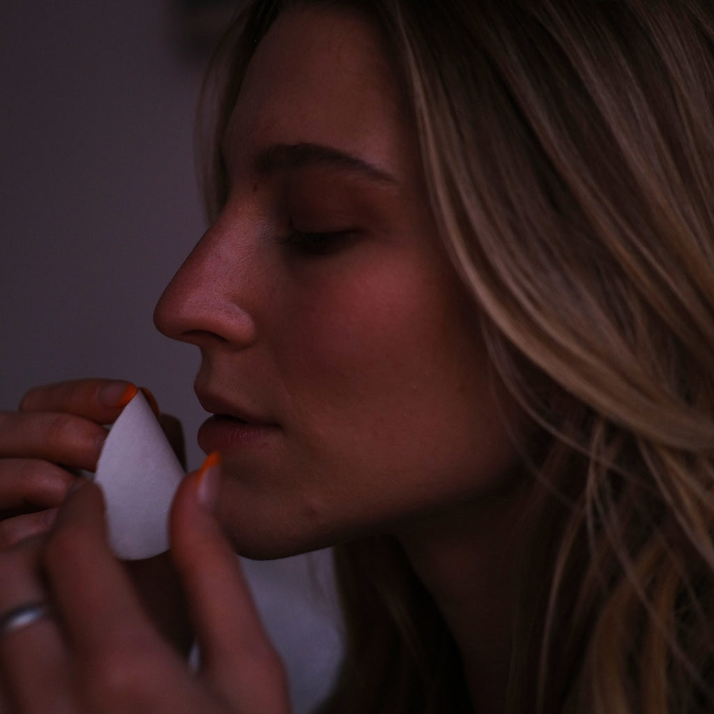 Close-up of a woman applying mouthtape on lips for sleep.